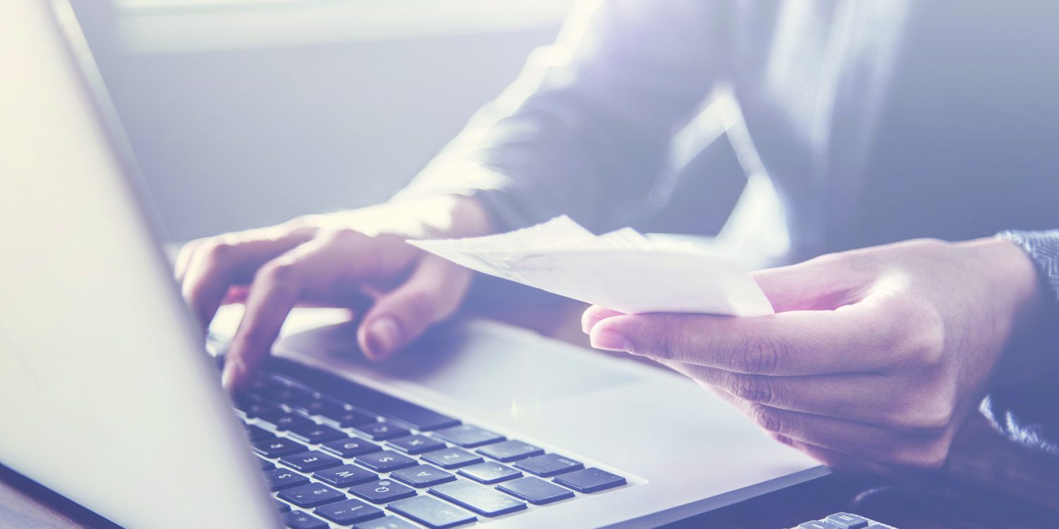 Person paying invoice to computer
