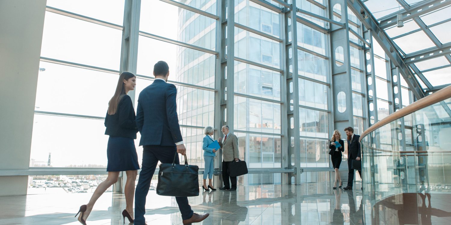 Business people walking in modern glass office building